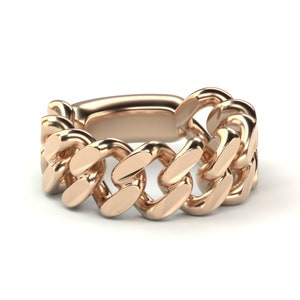 May include: A gold-toned ring featuring a thick, chunky chain design. The ring is made of metal and has a polished finish.