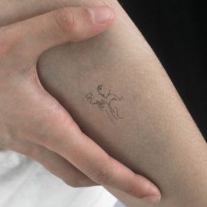 May include: A line drawing tattoo of a person smoking a cigarette.