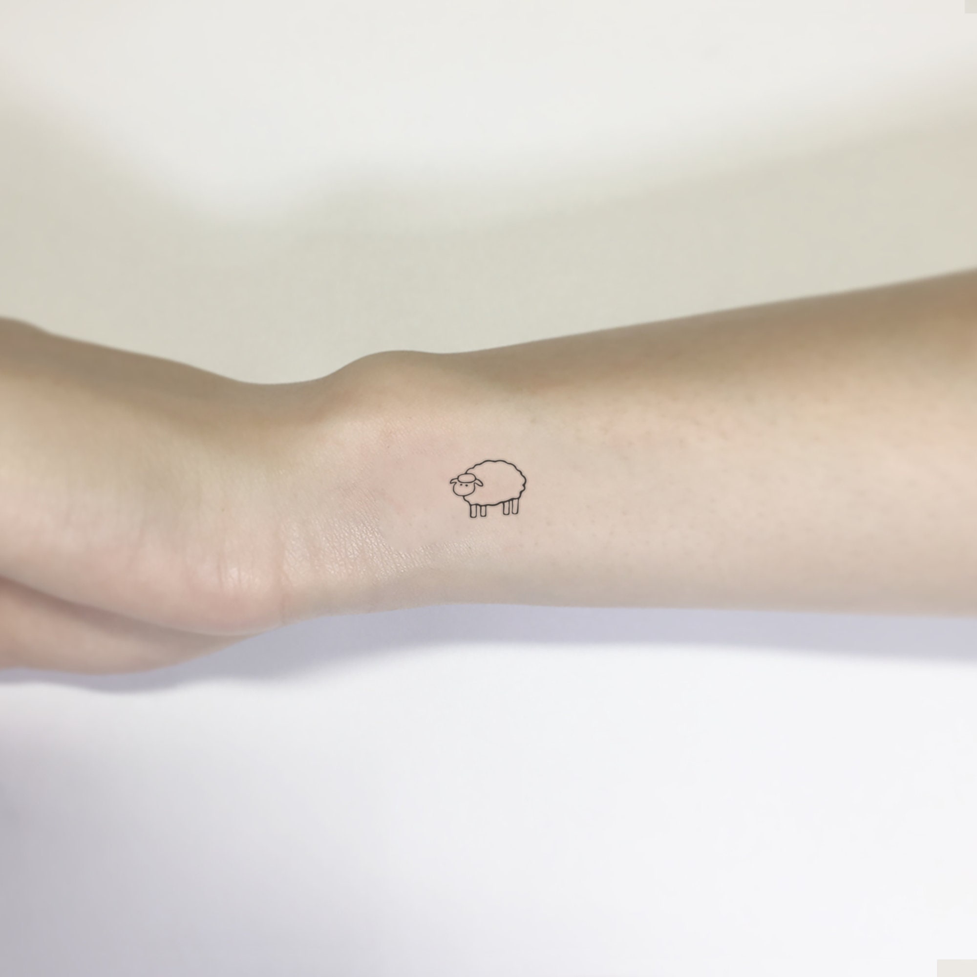 Minimalist sheep tattoo on the wrist