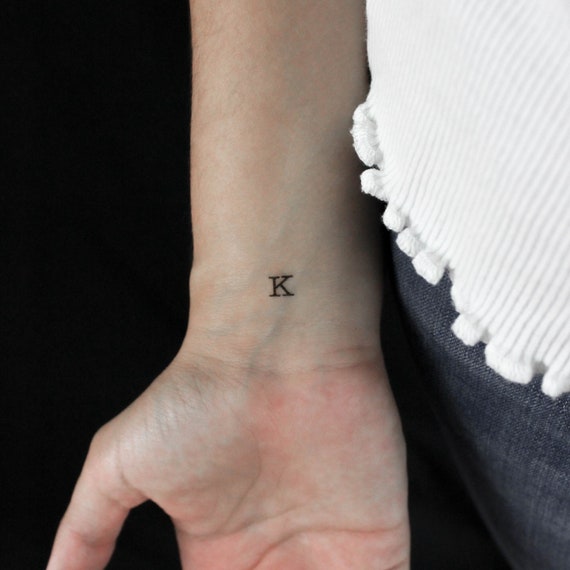 FRESHONTHEFLESH @tattoosolution #K #lettertattoo #scriptart ...