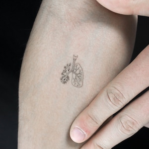 Może przedstawiać: Mały tatuaż z rysunkiem liniowym płuca z kwiatami rosnącymi z niego.