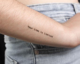 May include: A person's arm with a tattoo that reads "Your time is limited."