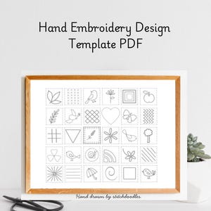 May include: A framed print with a wooden frame displays a hand embroidery design template. The template features a grid of small squares, each containing a different simple design, such as a bird, leaf, heart, and geometric shapes. The text "Hand Embroidery Design Template PDF" is at the top.