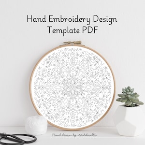 Pode incluir: Um modelo PDF de design de bordado à mão em um bastidor de madeira. O design apresenta um padrão floral detalhado em preto e branco. O texto na imagem diz "Hand Embroidery Design Template PDF" e "Hand drawn by stitchdoodles".