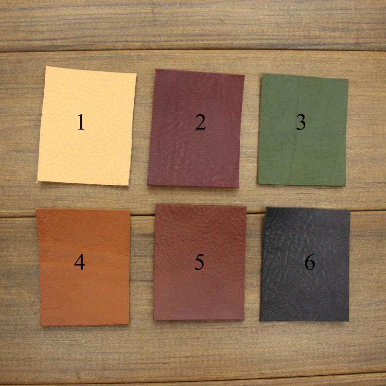May include: Six square leather swatches in various colors: light tan, burgundy, olive green, medium brown, dark brown, and black. Each swatch is numbered from 1 to 6.