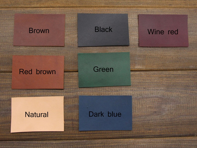 May include: A selection of rectangular leather swatches in colours such as brown, black, wine red, red brown, green, natural, and dark blue. Each swatch has its colour name printed on it.