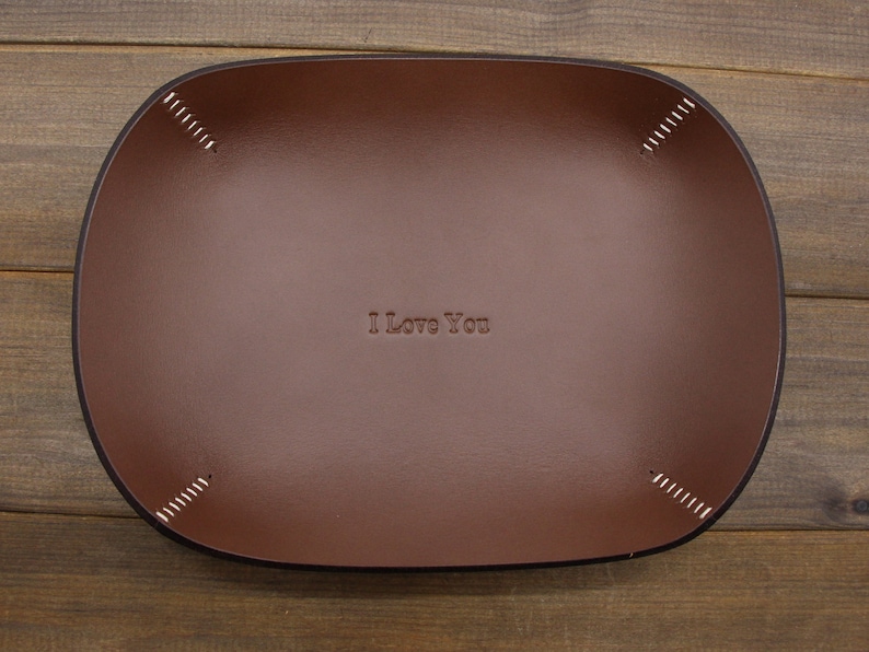 May include: A brown leather tray with stitched edges and the text "I Love You" embossed in the center.
