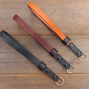 Pu&ograve; includere: Tre portachiavi in ​​pelle con anelli metallici neri e bottoni neri. I portachiavi sono marroni, marrone scuro e neri.