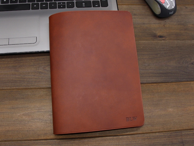 May include: A brown leather notebook cover with the initials "BLW" embossed on the front.