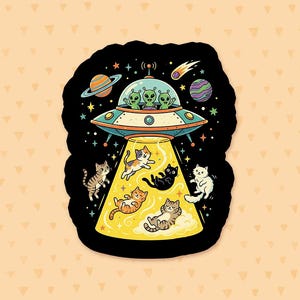 May include: A die-cut sticker featuring a black background with a colorful illustration of a flying saucer piloted by three green aliens. A bright yellow tractor beam extends downward, lifting five cats of various colors and patterns into space.