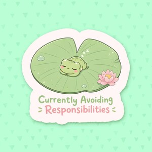 May include: A die-cut sticker featuring a light green frog sleeping on a large green lily pad with a pink water lily flower. The text below the frog reads Currently Avoiding Responsibilities in green and pink lettering on a white background.