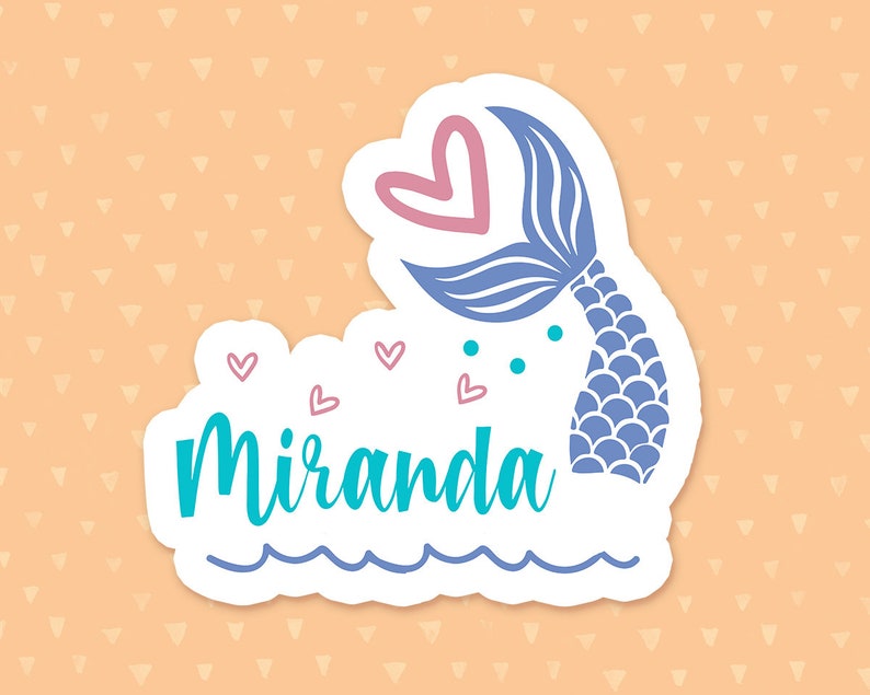 Puede incluir: Una pegatina blanca con una cola de sirena azul, corazones rosas y el nombre "Miranda" en texto turquesa. La pegatina tiene una l&iacute;nea azul ondulada en la parte inferior, que representa el agua.