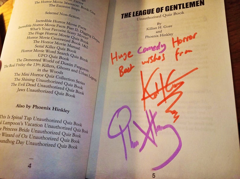 May include: A book titled "The League of Gentlemen: Unauthorised Quiz Book" by Killian H. Gore and Phoenix Hinkley. The book has a handwritten message that says "Huge Comedy Horror Best wishes from" and is signed by "K.H.G." in red and "P.H." in purple.