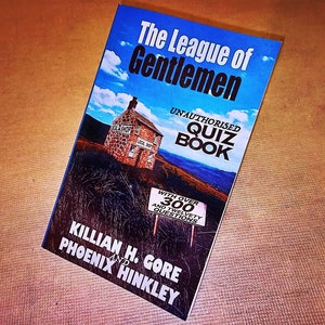 May include: A book titled "The League of Gentlemen Unauthorised Quiz Book" with a blue sky and a stone building on the cover. The book has over 300 questions and is written by Killian H. Gore and Phoenix Hinkley.