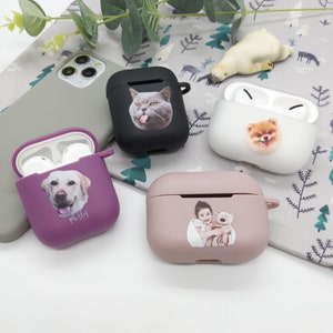 Pode incluir: Quatro capas AirPod diferentes com designs personalizados. As capas são preta, roxa, branca e rosa. Os designs incluem um gato, um cachorro, uma menina com um urso de pelúcia e um cachorro. As capas estão todas fechadas.