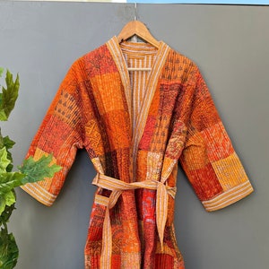 Peut inclure: Une robe de chambre matelassée en patchwork dans des tons d'orange, de jaune et de rouge avec une ceinture à nouer. La robe a un style kimono japonais traditionnel.