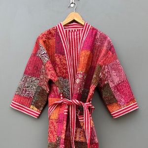 Peut inclure: Une robe de chambre matelassée en patchwork rouge et rose avec une ceinture rayée blanche et rouge. La robe est de style kimono japonais traditionnel.