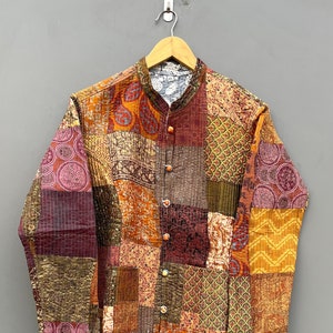 May include: A patchwork quilted jacket with a mandarin collar and button fastening. The jacket is made from a variety of fabrics in shades of brown, orange, and red. The fabric has a paisley and floral pattern.