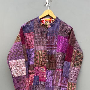 May include: A purple and pink patchwork quilted jacket with a mandarin collar and button closure.