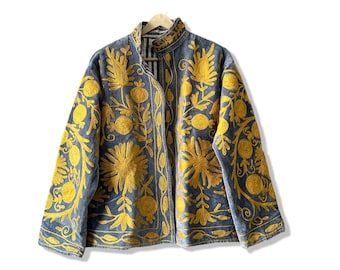 May include: A blue velvet jacket with intricate yellow floral embroidery. The jacket has a mandarin collar and a front closure.