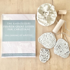 Może przedstawiać: Książka zatytułowana "The Montessori Fourth Great Lesson for Christians: The Coming of Writing" autorstwa Modern Classical Homeschool. Książka jest otwarta na stronie z jasnoniebieskim tłem i białym tekstem. Na drewnianej powierzchni leży pięć białych przedmiotów z gliny. Przedmioty to kula, prostokąt i trzy nieregularne kształty.
