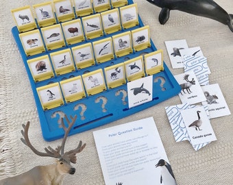 Könnte beinhalten: Ein blaues und gelbes Spielbrett mit Bildern von arktischen Tieren. Das Spiel heißt "Wer ist wer?" und enthält Karten mit Fragen zu den Tieren. Es gibt auch Spielzeugtierfiguren, darunter ein Rentier, ein Pinguin und ein Orca.