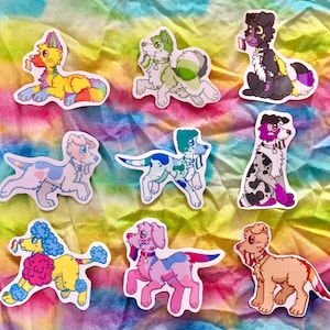 Peut inclure: Dix autocollants de chiens colorés avec différents motifs et couleurs. Les autocollants sont sur un fond tie-dye arc-en-ciel.