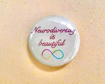以下が含まれることがあります： 白地に「Neurodiversity is beautiful」という文字がマロン色の筆記体で書かれたボタン。文字の下には虹色の無限大記号があります。