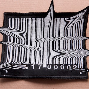 Puede incluir: Un parche de código de barras en blanco y negro con un efecto distorsionado y ondulado. El número del código de barras es 17000002.