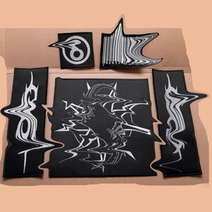 May include: A set of five black and white iron-on patches with a distorted, glitch-like design. The patches feature abstract shapes, a barcode, and the number "8".