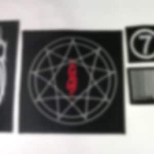 May include: A collection of black patches featuring white and red graphics. Designs include a stylized 'S' shape, a geometric star pattern with a central symbol, the number '7' in a circle, and a barcode.