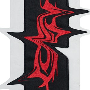 May include: Black and red embroidered patch with a stylized design. The design is abstract and resembles a flame or a wave.