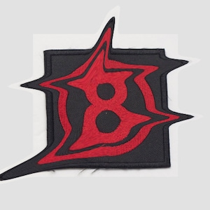 May include: Red embroidered patch with a stylized number eight on a black background.