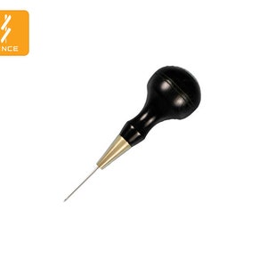 May include: A black and gold leather crafting tool with a wooden handle. The tool has a sharp, pointed tip.