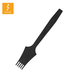 May include: Black leather crafting tool with a handle and a row of prongs at the end. The tool is labeled "306675" and "SINCE".