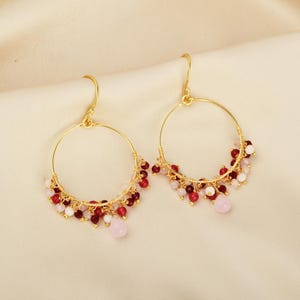 Puede incluir: Pendientes de aro dorados con cuentas rojas, rosas y blancas colgantes. El dise&ntilde;o es sencillo y elegante, ideal para uso diario u ocasiones especiales. Di&aacute;metro: aproximadamente 4 cm.