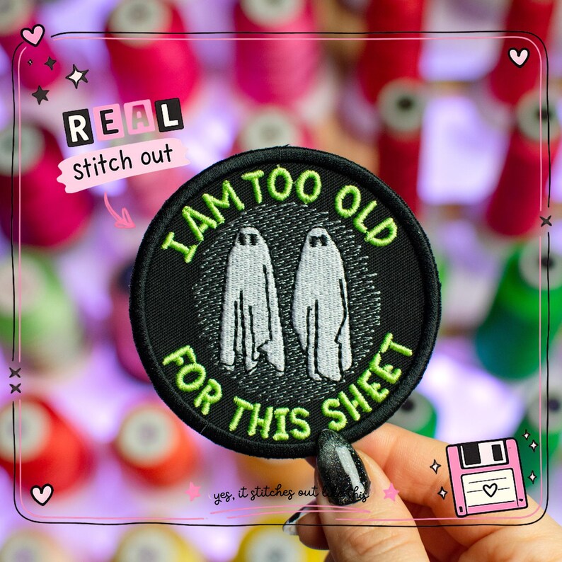 May include: Black circular patch with the text "I AM TOO OLD FOR THIS SHEET" in green and two ghost figures. The patch is embroidered with white thread and has a black border. The words "REAL stitch out" are also visible.
