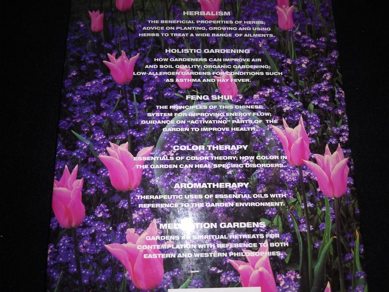 May include: A book cover with a pink and purple floral design. The text on the cover reads "Herbalism", "Holistic Gardening", "Feng Shui", "Color Therapy", "Aromatherapy", and "Meditation Gardens".