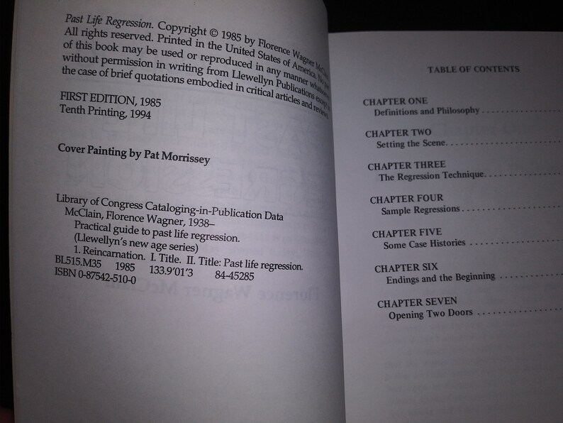 May include: A book titled "Past Life Regression" by Florence Wagner McClain. The book cover features a white background with black text. The book is a practical guide to past life regression and includes information on reincarnation. The book was published in 1985 and is part of Llewellyn's New Age Series.