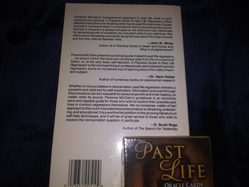 Puede incluir: Un libro titulado "A Practical Guide to Past Life Regression" de Florence McClain. La contraportada presenta citas de John W. White, Dr. Hans Holzer y D. Scott Rogo, todos autores de libros sobre el tema de las vidas pasadas y la reencarnaci&oacute;n. La portada del libro es blanca con texto negro.