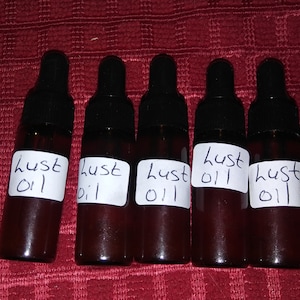 May include: Six small brown glass bottles with droppers, each labeled "lust oil" in black handwritten text.