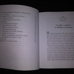 May include: Open book with text about spirituality, including topics like removing negative vibrations, communicating with spirits, and enhancing psychic abilities. Chapter 1 discusses candles and fire in religious history.
