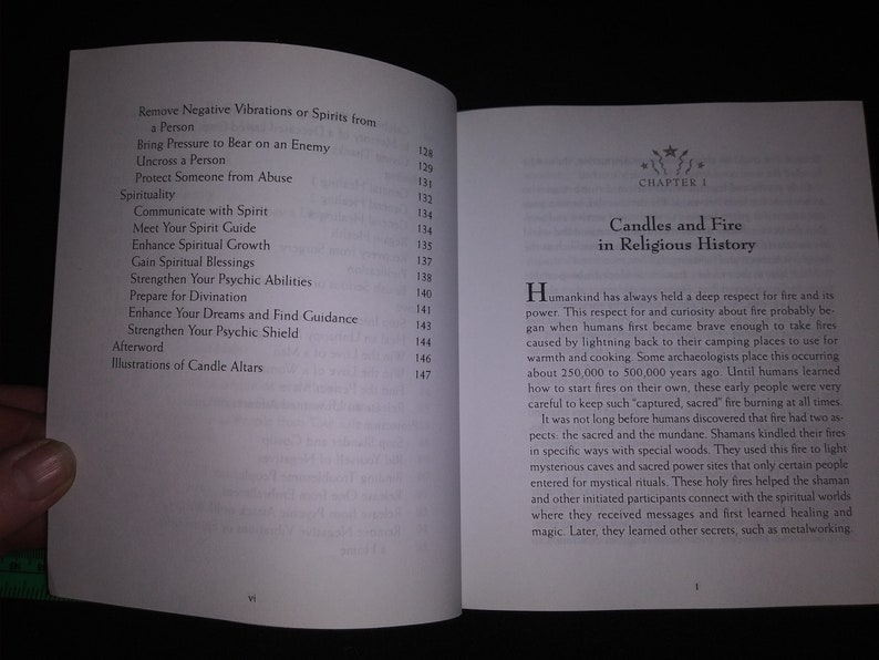 May include: Open book with text about spirituality, including topics like removing negative vibrations, communicating with spirits, and enhancing psychic abilities. Chapter 1 discusses candles and fire in religious history.