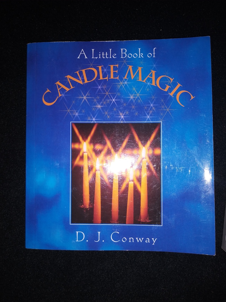 May include: A Little Book of Candle Magic by D. J. Conway. The book cover is a deep blue with the title in orange. The cover features an image of lit candles with bright flames.
