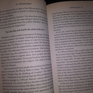 May include: Open book with a tan cover and white pages. The text on the page is about the Wiccan Rede and the responsibilities of a Wiccan Warrior. The text includes the quote "Do what thou wilt shall be the whole of the law."