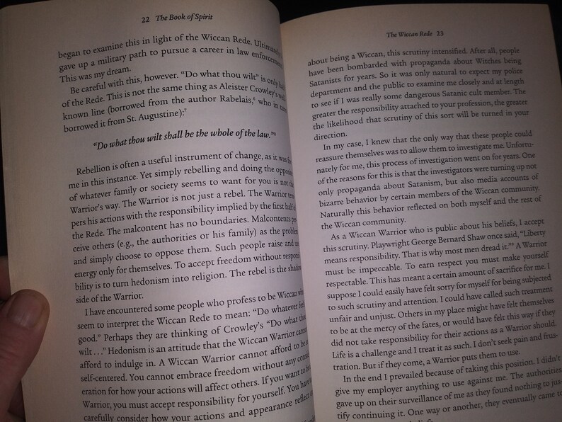 May include: Open book with a tan cover and white pages. The text on the page is about the Wiccan Rede and the responsibilities of a Wiccan Warrior. The text includes the quote "Do what thou wilt shall be the whole of the law."