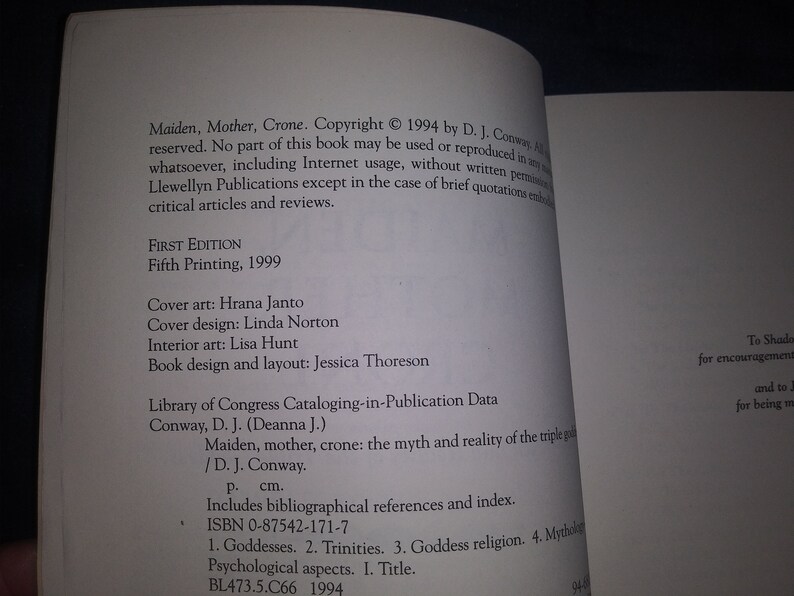 May include: A book titled "Maiden, Mother, Crone: The Myth and Reality of the Triple Goddess" by D.J. Conway. The book cover is white with black text. The book is a fifth printing from 1999.