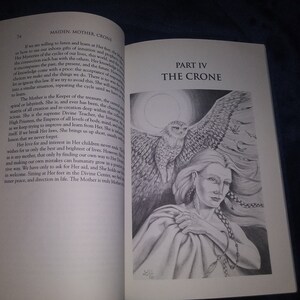 May include: A black and white illustration of a woman with long hair and a bird perched on her shoulder. The woman is wearing a long robe and has her arms crossed. The text "PART IV THE CRONE" is printed in black at the top of the page.