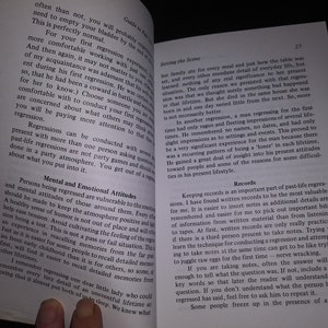 May include: An open book with a white background. The book is titled "Guide to Past Life Regression" and the text discusses the importance of keeping records of past life regressions. The text also discusses the importance of having a positive and supportive atmosphere during a regression session.