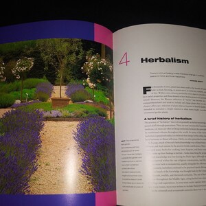 May include: A book open to a page about herbalism, with the number 4 highlighted. The page features text about the history of herbalism and a photo of a garden with lavender plants and a stone path.